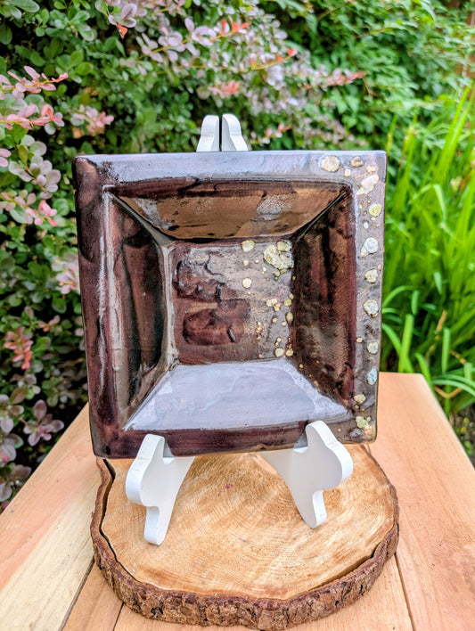 Celebrate the beauty of handcrafted ceramics with this square studio pottery dish featuring layered reactive glazes in rich chocolate brown, gray, olive, cream, and golden crystalline accents. Perfect as a catchall tray, jewelry dish, appetizer plate, or decorative accent, it brings organic warmth to any space.
