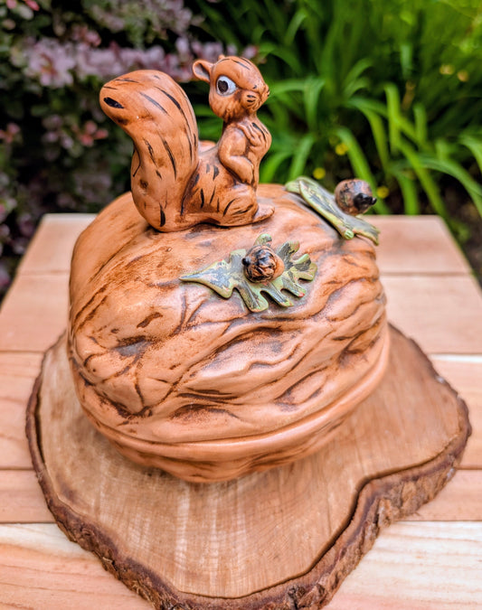 Celebrate the charm of 1970s woodland décor with this vintage Arnel's ceramic walnut-shaped covered dish featuring a beautifully hand-painted squirrel finial. Perfect as a decorative candy dish, seasonal accent, or rustic display piece for cottage and cabin-inspired interiors.