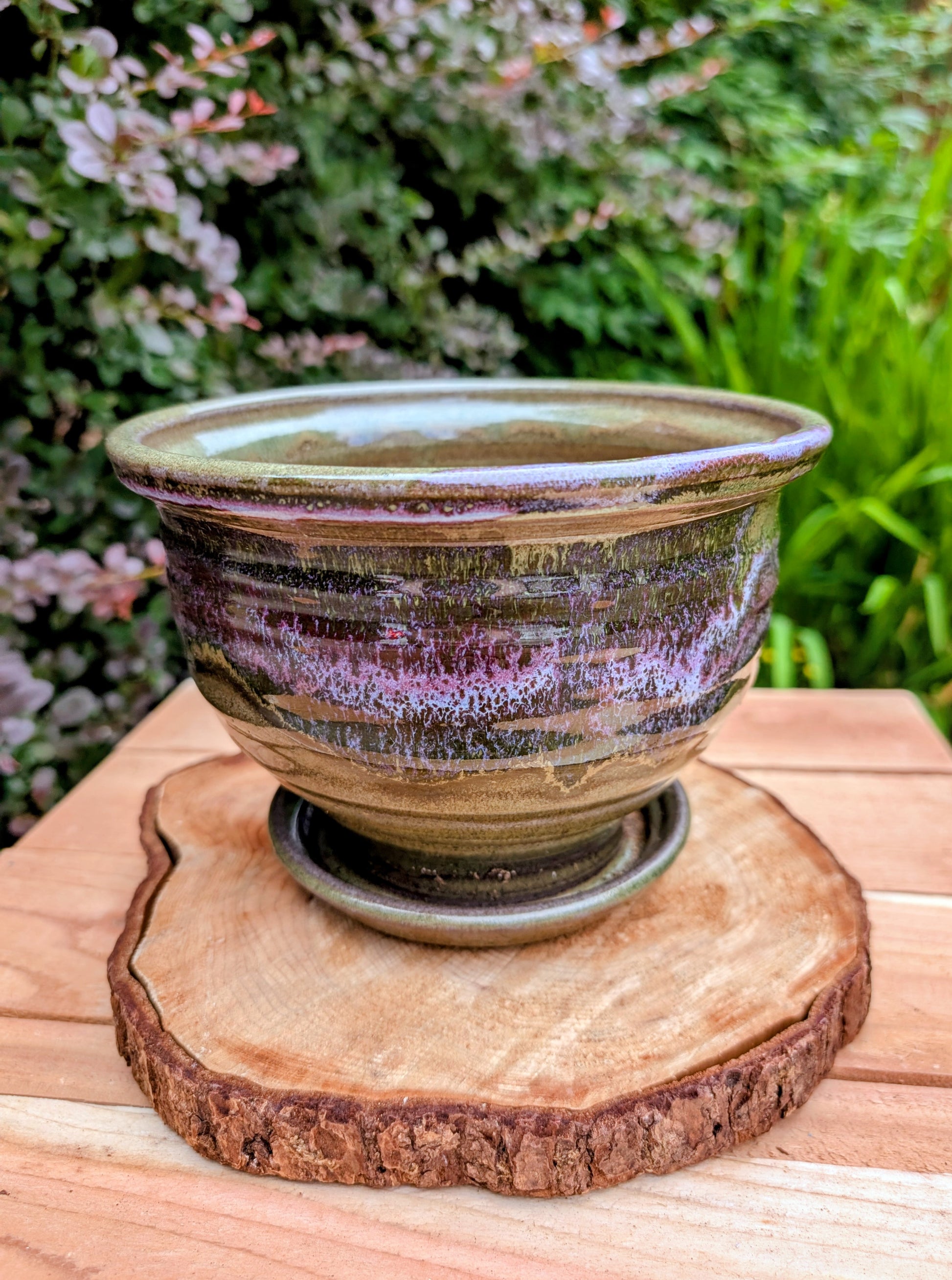 Handcrafted in Snohomish, Washington, this authentic Bruning Pottery stoneware planter showcases flowing moss green, olive, brown, and plum glazes inspired by the Pacific Northwest landscape. Complete with an integrated saucer, it's a beautiful and functional piece for houseplants, herbs, or succulent collections.