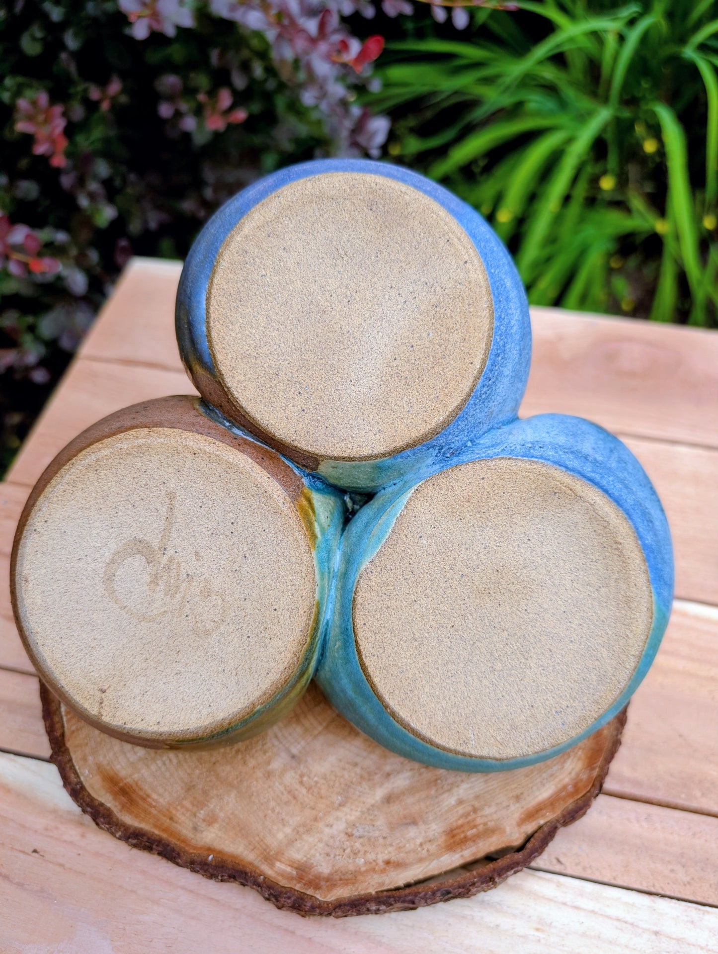 Beautifully handcrafted and artist signed, this three-bowl stoneware condiment server combines sculptural artistry with everyday functionality. Finished in layered seafoam, aqua, moss, and earthy glazes, it brings timeless craftsmanship and Pacific Northwest-inspired beauty to entertaining.
