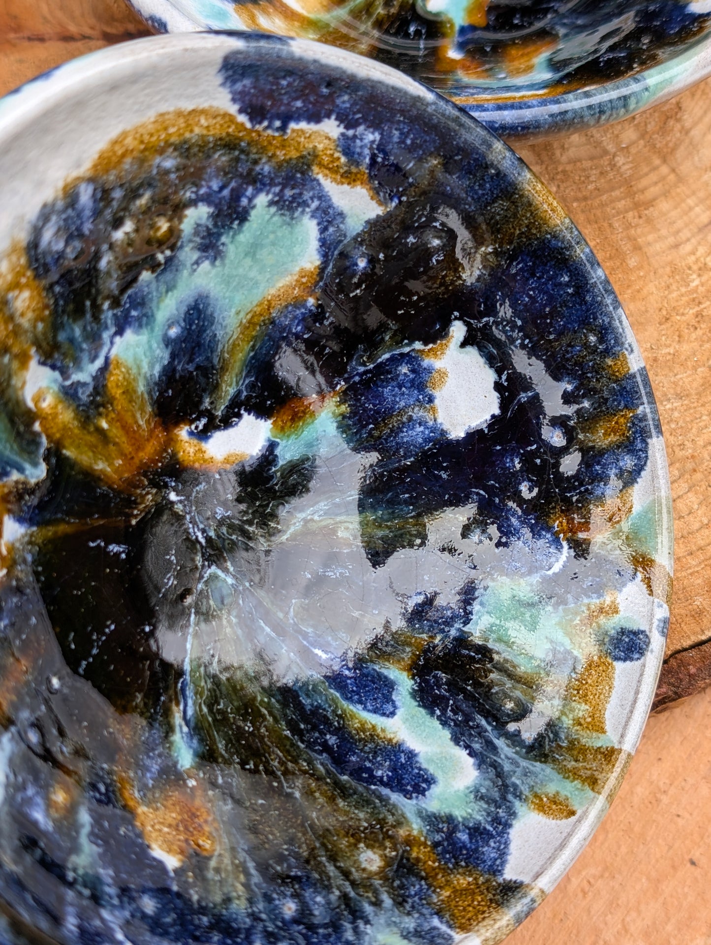 Bring handcrafted artistry to your table with this matching pair of signed studio pottery bowls. Finished with richly layered reactive glazes in cobalt blue, teal, amber, and ivory, these versatile artisan bowls are equally beautiful for entertaining or everyday display.