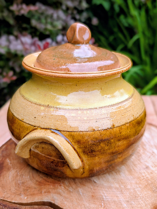 Bring timeless craftsmanship to your kitchen with this handcrafted studio pottery lidded stoneware pot. Finished in warm honey, caramel, olive, and tan glazes, this versatile covered vessel is equally beautiful as functional serveware or rustic farmhouse décor.