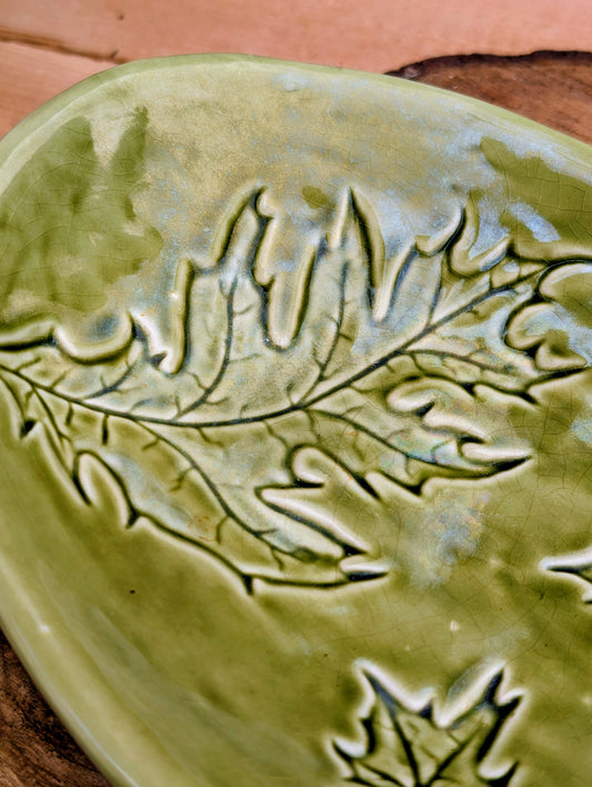 Celebrate the beauty of the forest with this handcrafted embossed oak leaf ceramic dish. Featuring a rich olive-green glaze and an organic form, it's equally at home serving small bites, holding jewelry, or adding a touch of Pacific Northwest charm to your décor.