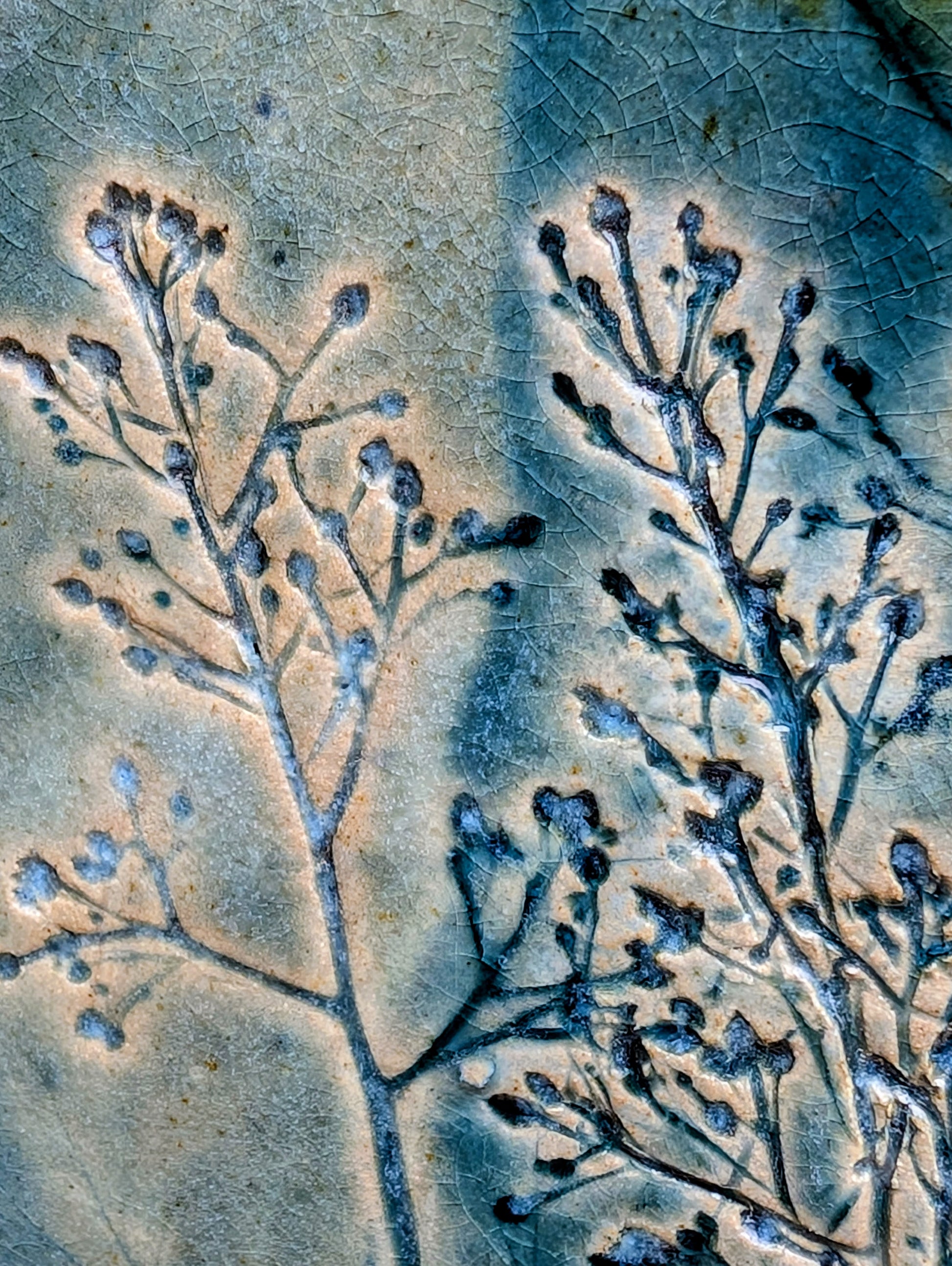 Celebrate the beauty of nature with this signed handbuilt studio pottery platter featuring an elegant botanical relief impressed directly into the clay. Finished in layered blue, teal, and olive glazes, this contemporary stoneware piece is equally at home as functional serveware or displayed as ceramic wall art.