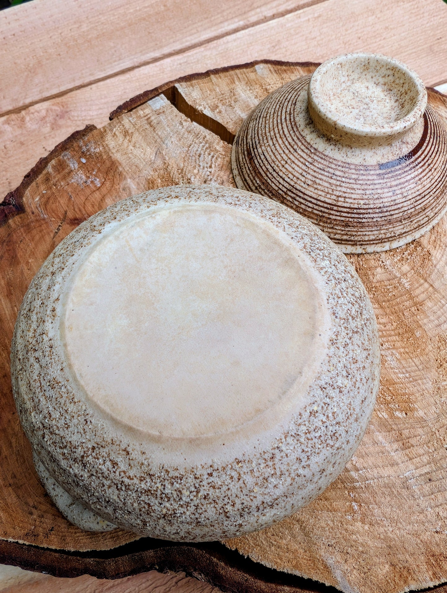 A beautifully handcrafted studio pottery bowl featuring a warm speckled stoneware exterior, vibrant turquoise glazed interior, and matching ribbed lid. Its compact size and organic design make it perfect for serving small dishes or displaying as a timeless piece of artisan pottery.