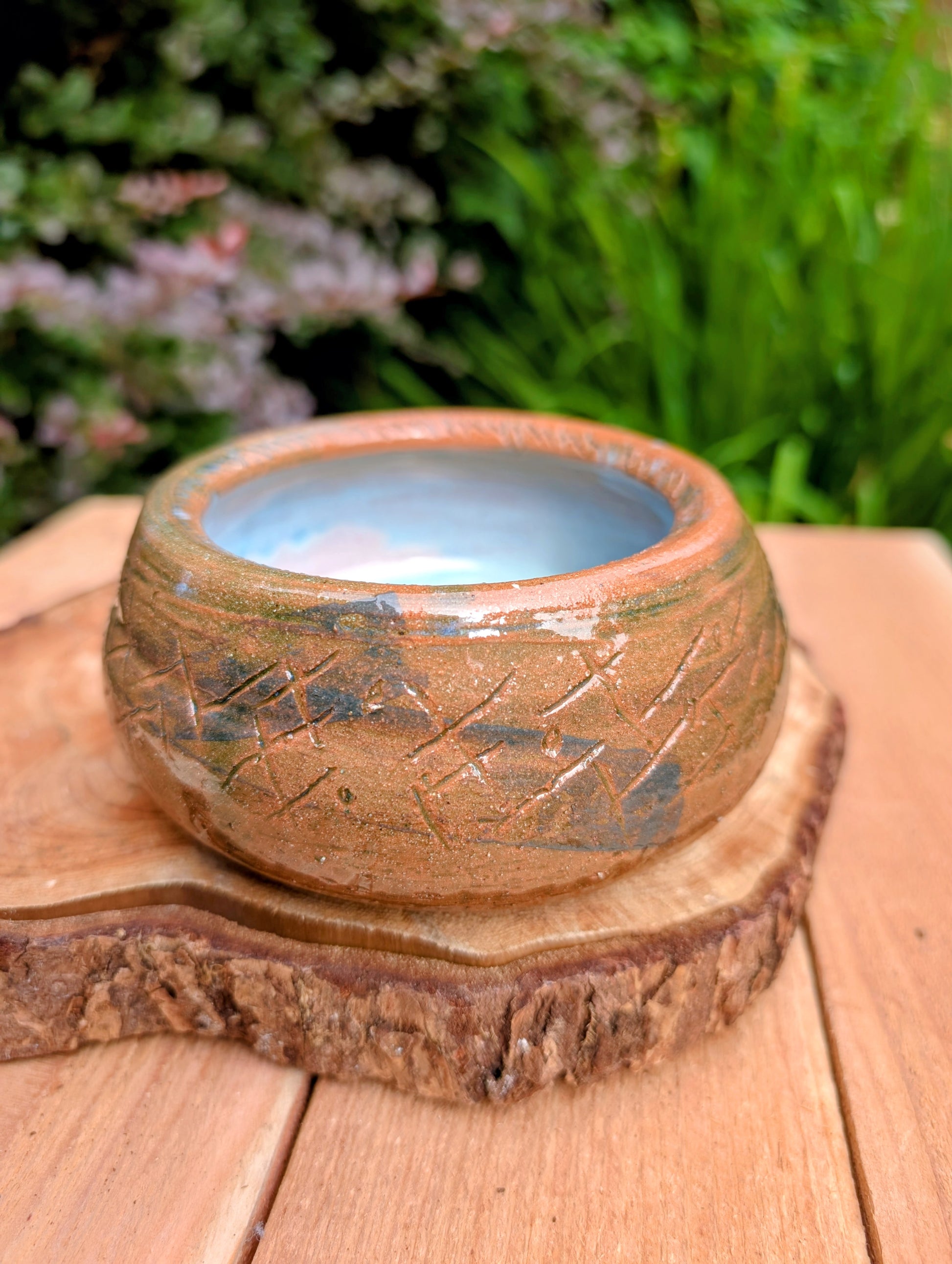 Handcrafted with richly carved texture and a soft blue reactive glaze, this signed studio pottery bowl brings warmth and character to any home. Ideal as a serving bowl, decorative accent, or functional piece of everyday artisan pottery.