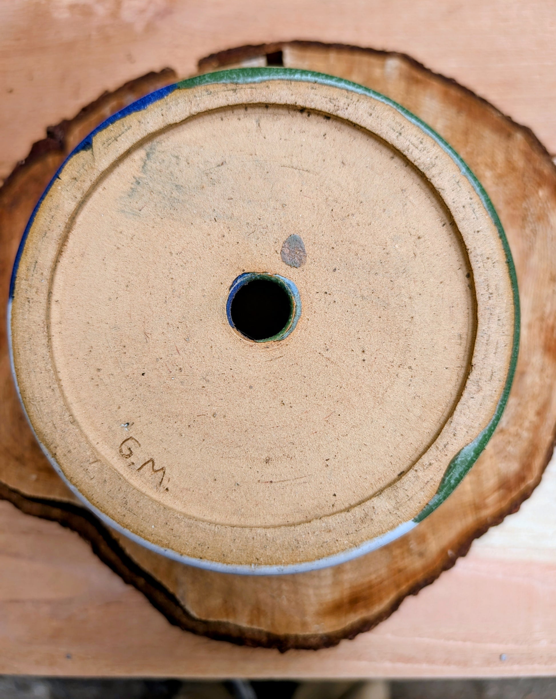 A beautifully hand-thrown studio pottery succulent planter featuring layered blue, moss green, and soft white glazes over high-fired stoneware. Complete with an integrated drainage hole and signed by the artist with the monogram "G.M.," this artisan planter brings handcrafted character to any home or garden.