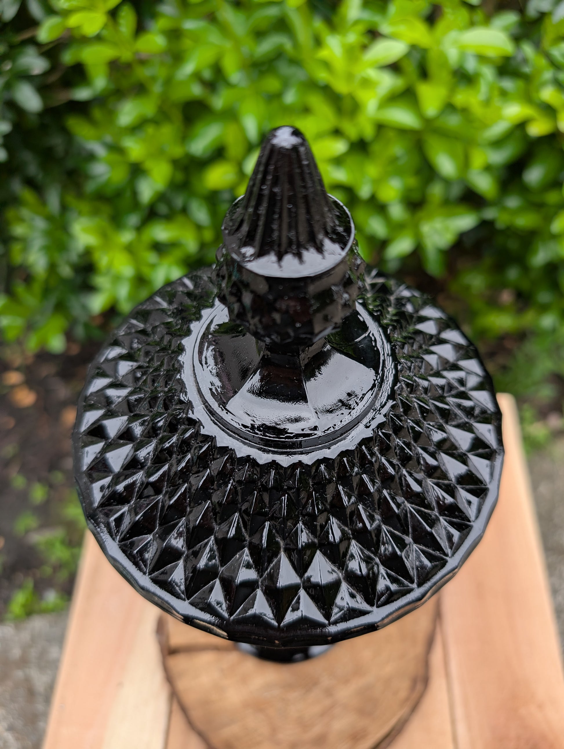 Make a dramatic statement with this vintage Tiara Exclusives Diamond Point covered pedestal compote in rich Cameo Black glass. Standing an impressive 16 inches tall, this elegant pressed glass piece is perfect for displaying wrapped candies, seasonal décor, ornaments, or treasured collectibles throughout the year.