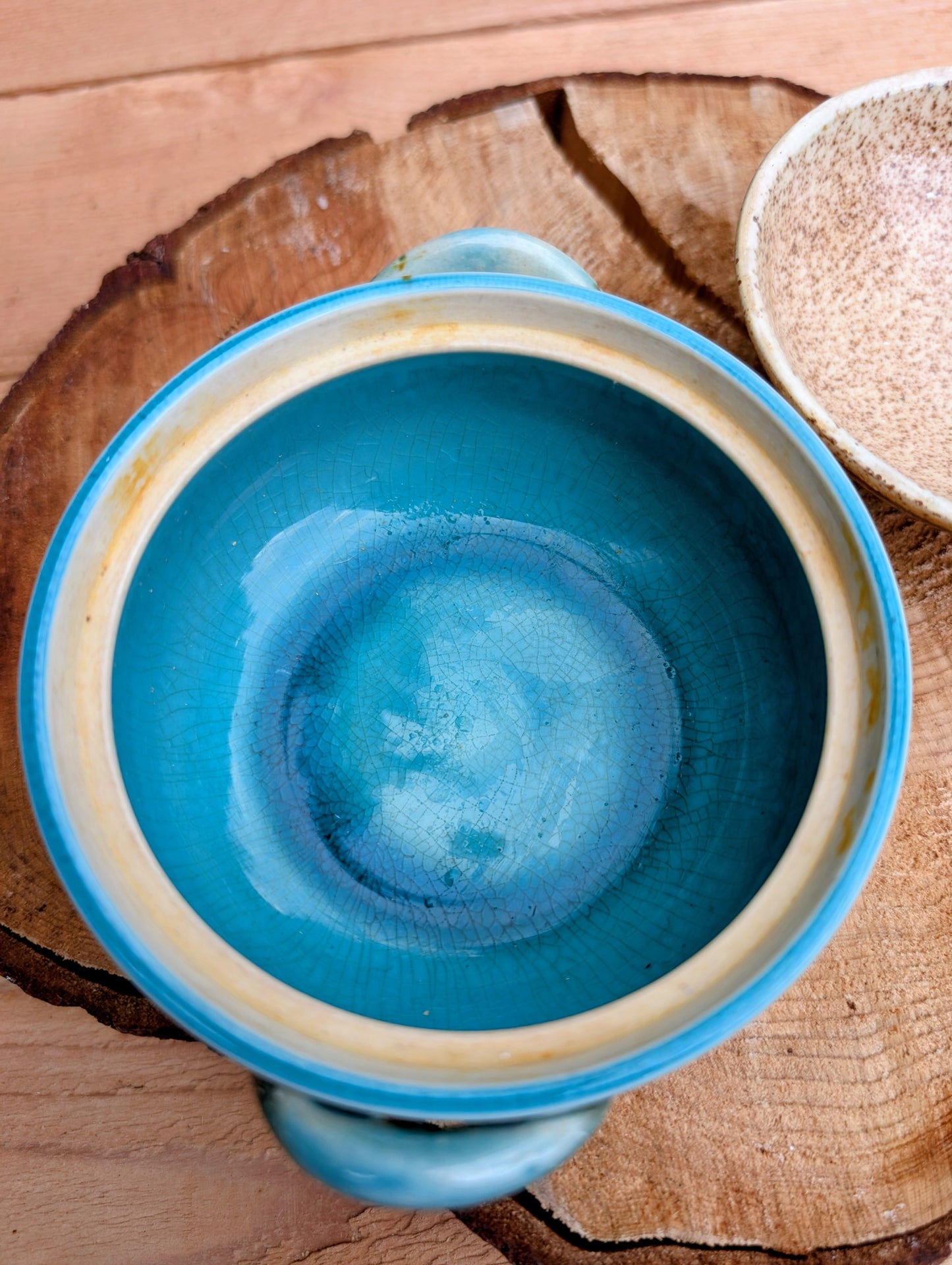 A beautifully handcrafted studio pottery bowl featuring a warm speckled stoneware exterior, vibrant turquoise glazed interior, and matching ribbed lid. Its compact size and organic design make it perfect for serving small dishes or displaying as a timeless piece of artisan pottery.