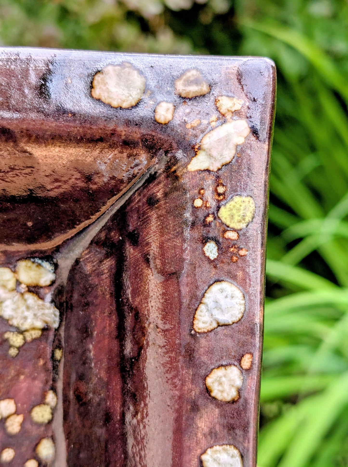 Celebrate the beauty of handcrafted ceramics with this square studio pottery dish featuring layered reactive glazes in rich chocolate brown, gray, olive, cream, and golden crystalline accents. Perfect as a catchall tray, jewelry dish, appetizer plate, or decorative accent, it brings organic warmth to any space.