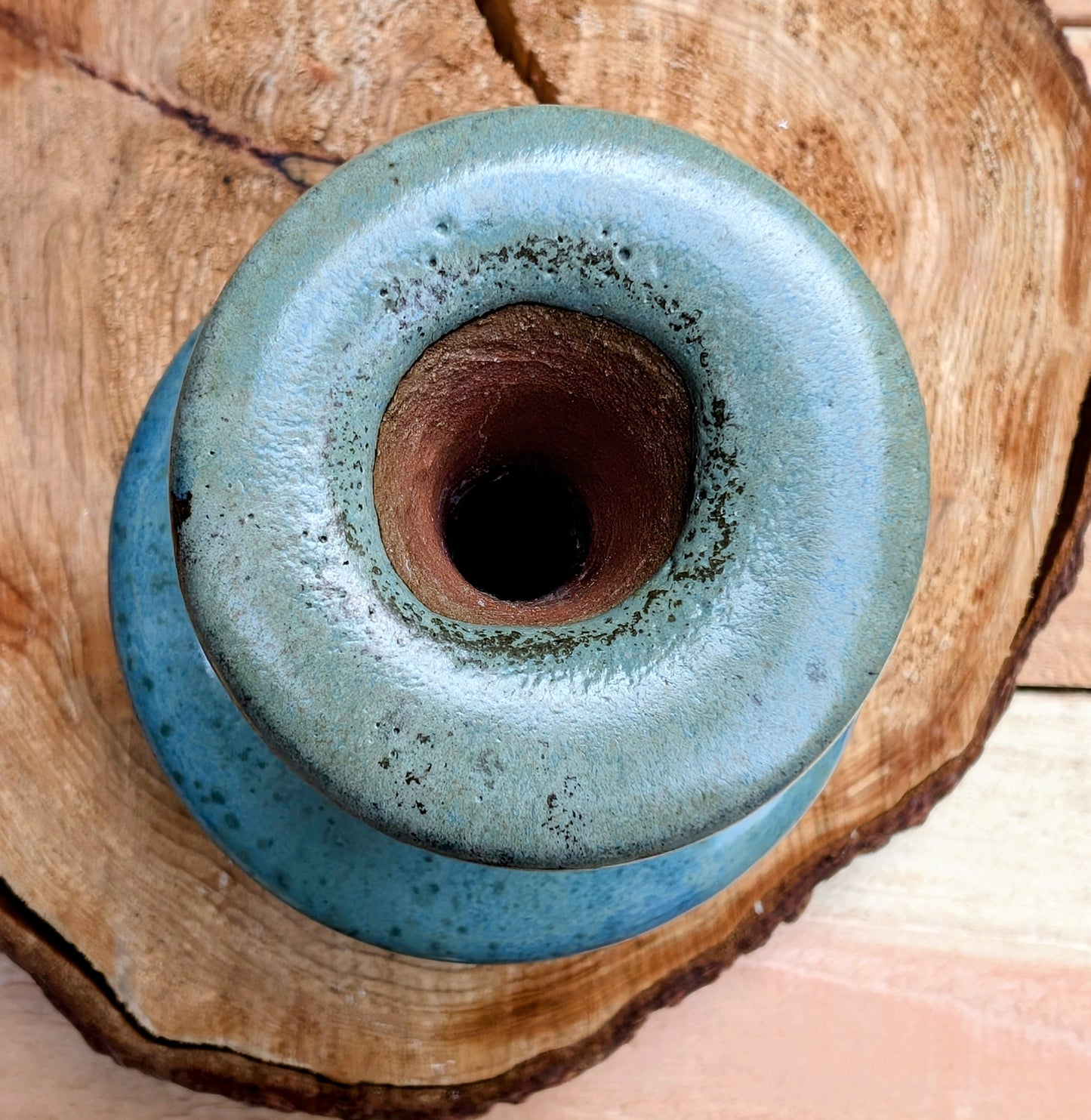 A beautifully hand-thrown studio pottery bud vase featuring a rich blue-green glaze over warm stoneware clay. Its timeless organic form makes it perfect for displaying a single bloom, dried botanicals, or as a sculptural accent in any room.
