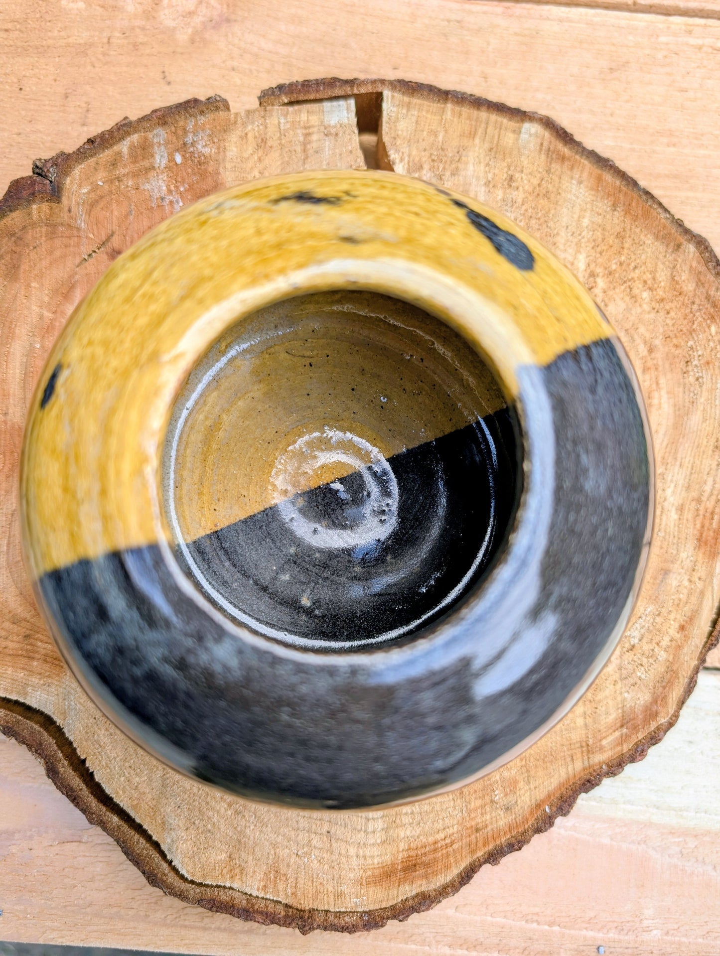 A beautifully hand-thrown studio pottery bud vase dated 1988, featuring a striking half-black, half-mustard glaze accented with expressive iron oxide speckling. Its sculptural form and organic craftsmanship make it equally at home as a minimalist floral vessel or standalone work of ceramic art.