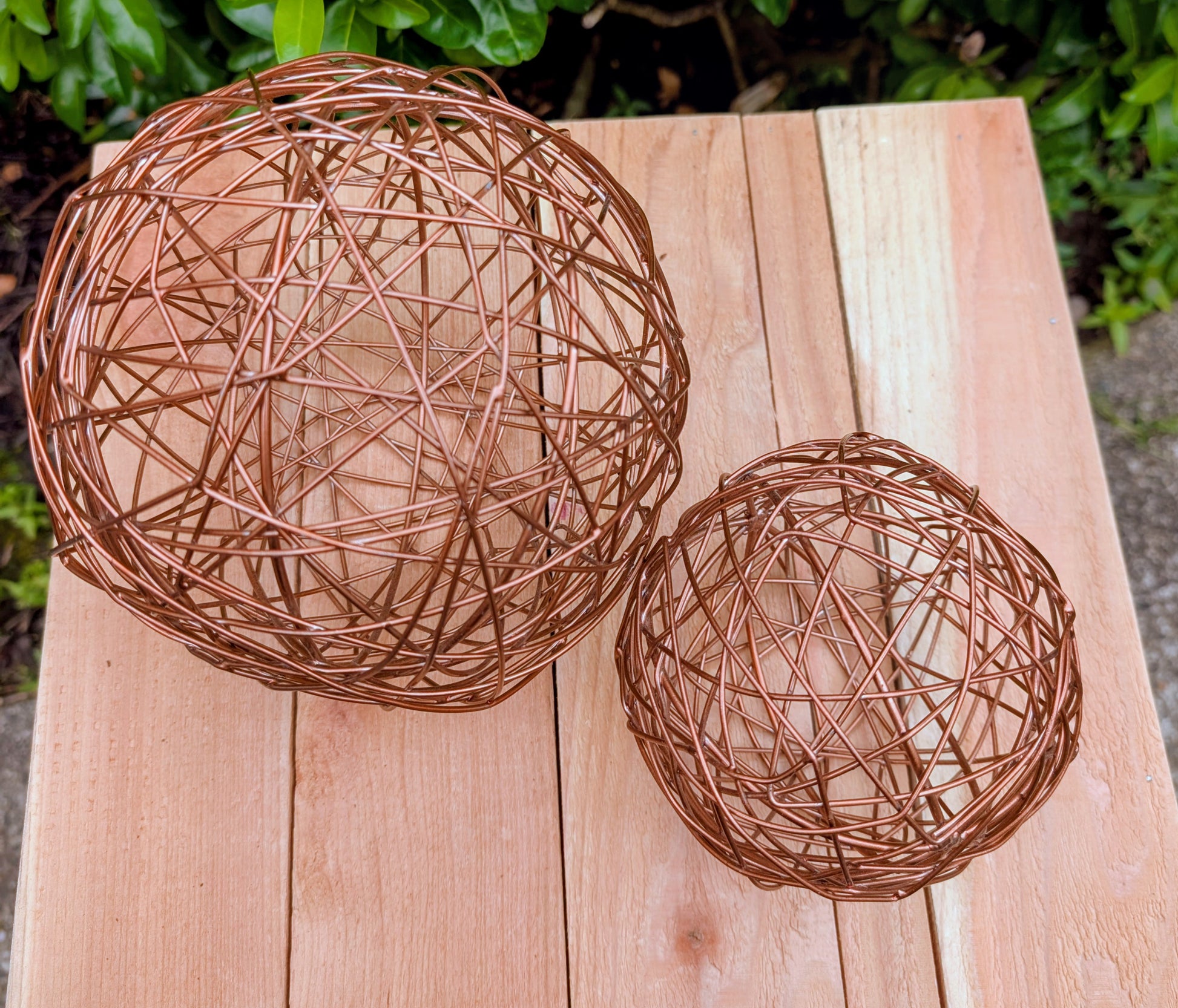 Bring warmth and texture to your home with this coordinated set of two copper-tone woven metal decorative spheres. Their sculptural open-weave design complements modern organic, farmhouse, industrial, and contemporary interiors, making them versatile accents for shelves, coffee tables, decorative bowls, and centerpieces.
