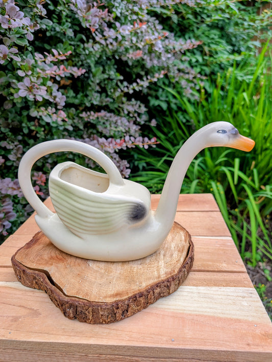 A charming 1950s Nouvelle Pottery swan watering pitcher that blends sculptural beauty with everyday function. Finished in a soft ivory glaze with hand-painted details, this Mid-Century ceramic piece is equally at home caring for houseplants or displayed as timeless vintage décor.