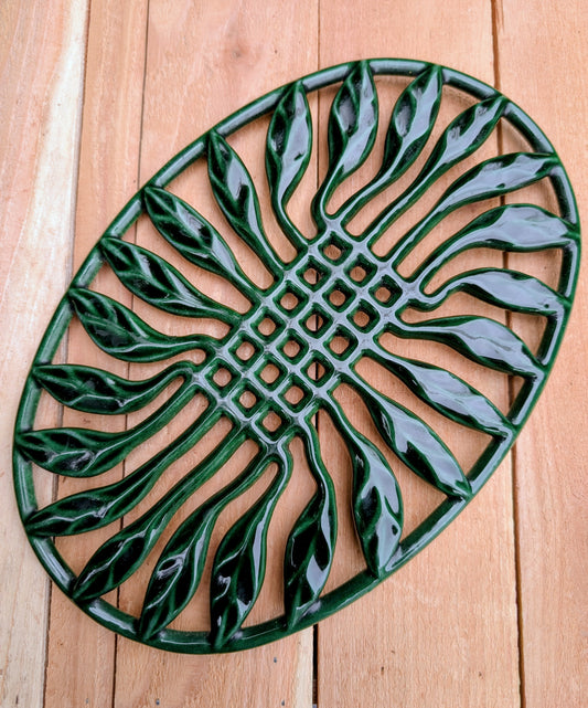 Bring timeless French craftsmanship to your kitchen with this vintage Invicta France cast iron trivet. Finished in a rich hunter green porcelain enamel, its elegant sunburst leaf design serves beautifully as both a functional hot plate and decorative wall accent.