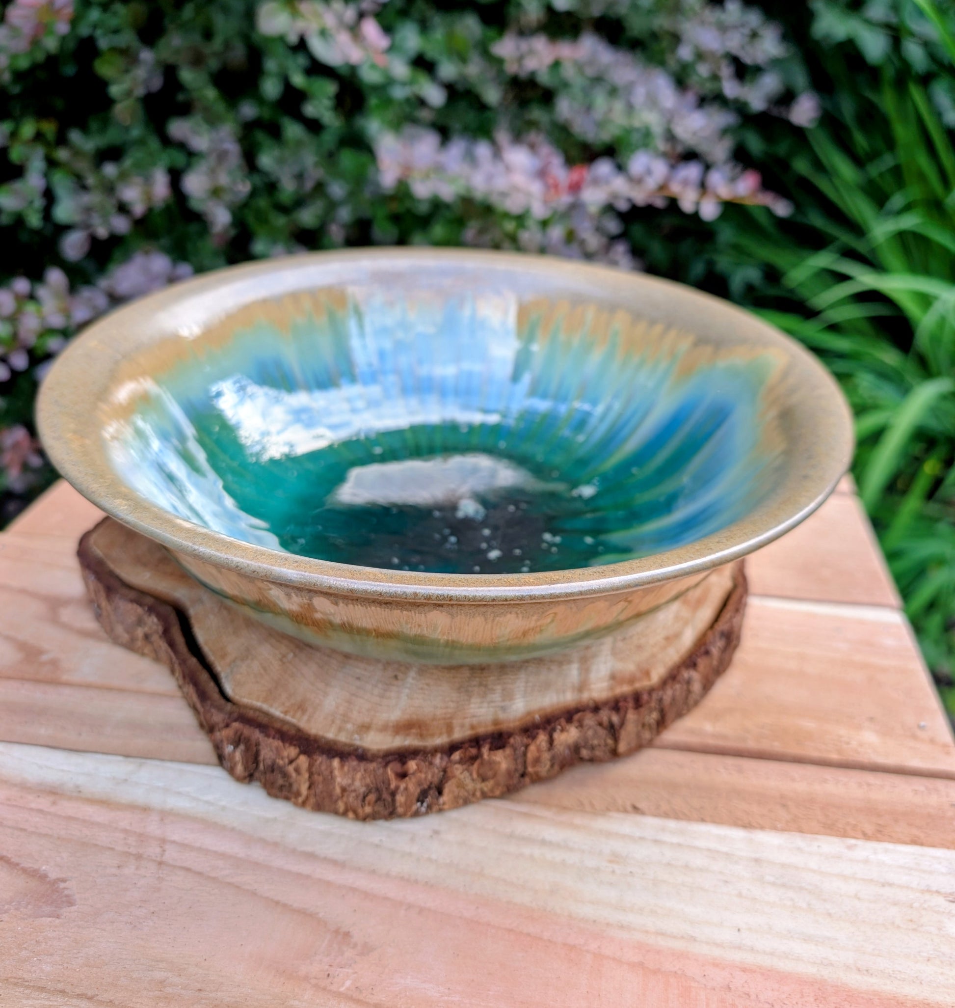 A beautifully handcrafted studio pottery bowl featuring layered blue, celadon, and copper reactive glazes with striking crystalline patterning. This artisan stoneware piece makes an eye-catching centerpiece or decorative accent inspired by the colors of Pacific Northwest waters.