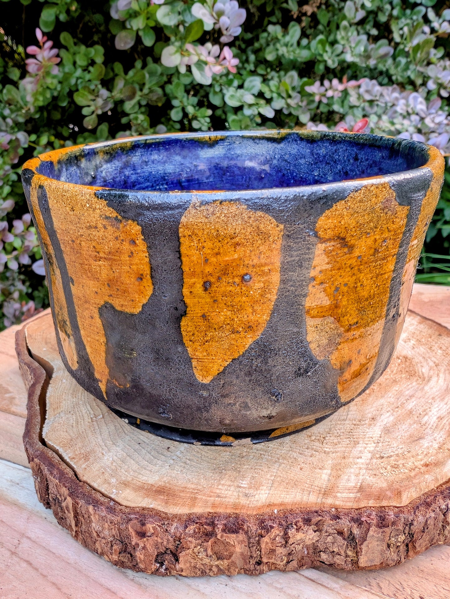 A beautifully hand-thrown studio pottery bowl featuring a rich cobalt blue interior, earthy ochre exterior, and expressive black drip glaze. Its timeless craftsmanship and organic design make it equally suited for serving, display, or adding artisan character to any Pacific Northwest-inspired home.