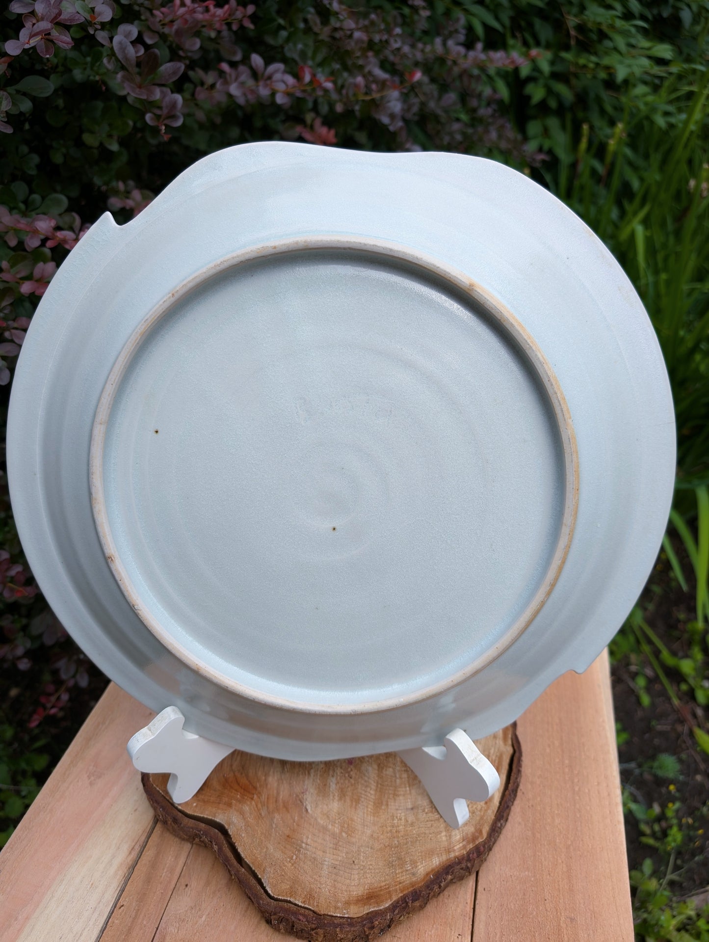 A beautifully handcrafted 14-inch studio pottery platter featuring layered abstract decoration in soft blue-gray, dusty pink, cream, and cobalt accents. Equally stunning as a serving piece or decorative display charger, this artisan-made platter brings timeless craftsmanship to modern living.
