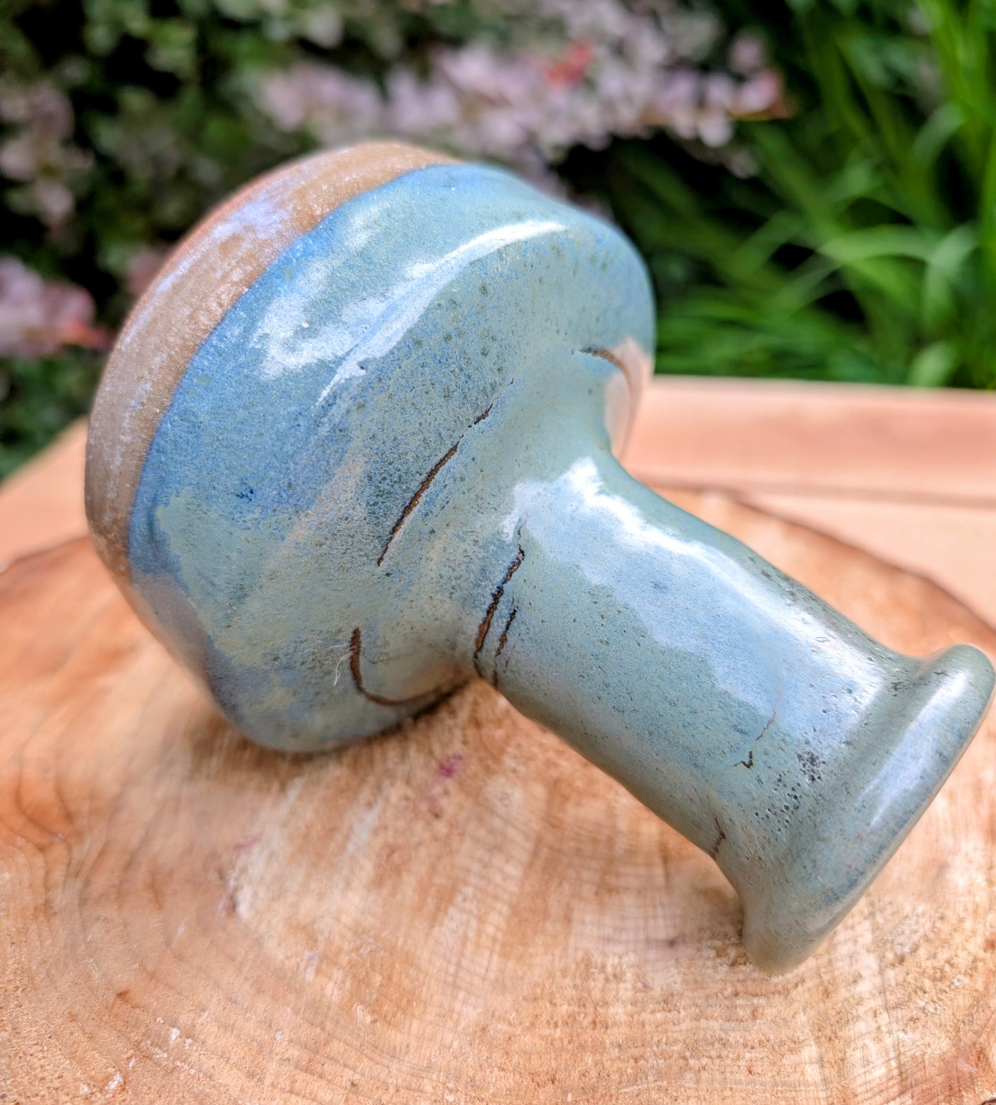 A beautifully hand-thrown studio pottery bud vase featuring a rich blue-green glaze over warm stoneware clay. Its timeless organic form makes it perfect for displaying a single bloom, dried botanicals, or as a sculptural accent in any room.