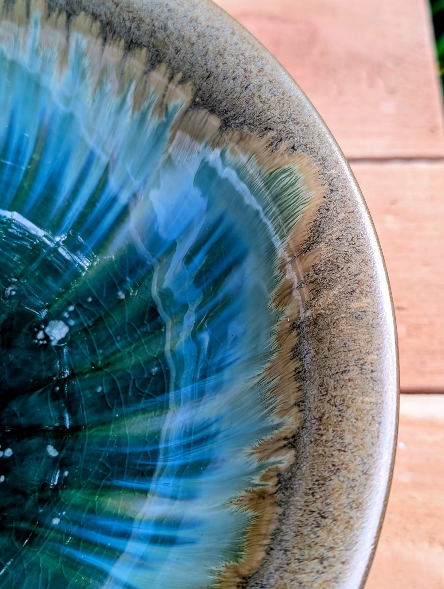 A beautifully handcrafted studio pottery bowl featuring layered blue, celadon, and copper reactive glazes with striking crystalline patterning. This artisan stoneware piece makes an eye-catching centerpiece or decorative accent inspired by the colors of Pacific Northwest waters.