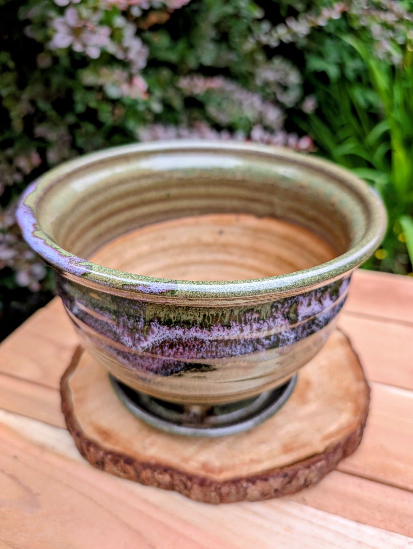 Handcrafted in Snohomish, Washington, this authentic Bruning Pottery stoneware planter showcases flowing moss green, olive, brown, and plum glazes inspired by the Pacific Northwest landscape. Complete with an integrated saucer, it's a beautiful and functional piece for houseplants, herbs, or succulent collections.