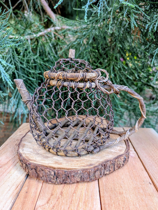 Bring the charm of handcrafted folk art into your home with this one-of-a-kind twig and wire teapot sculpture. Created from natural woodland materials, this whimsical decorative piece celebrates craftsmanship, imagination, and the beauty of nature.