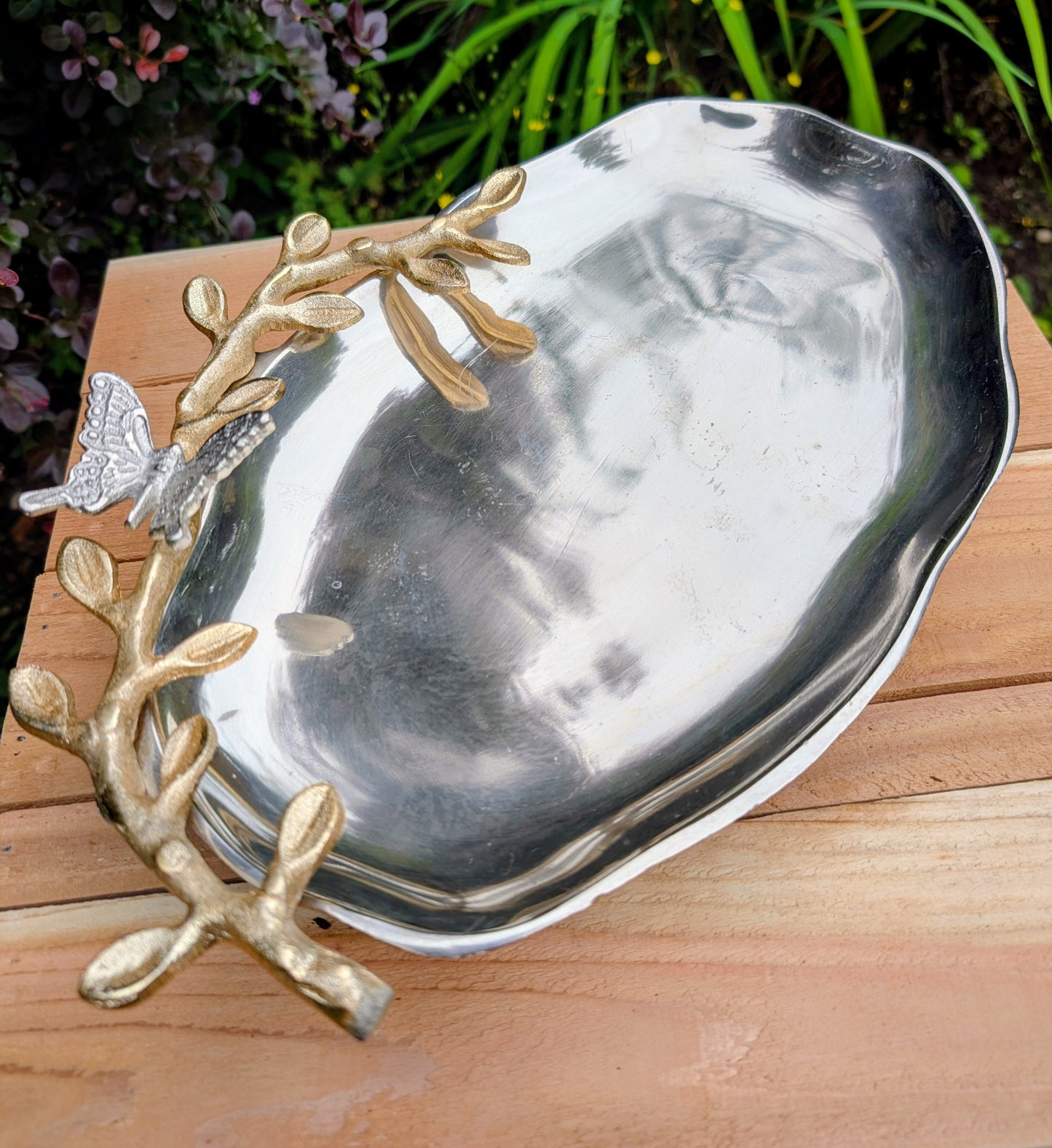 Bring the beauty of the forest indoors with this elegant cast aluminum serving platter featuring sculpted gold-tone branch handles and a delicate butterfly accent. Equally suited for entertaining or displaying seasonal décor, this nature-inspired piece blends organic artistry with timeless metallic finishes.